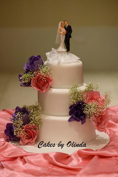 Simple wedding cake with pink and purple sugar roses with a hint of fresh babies breath - Cake by cakesbyolinda1