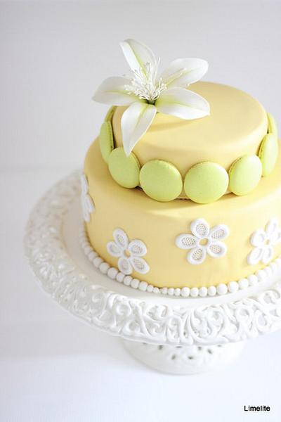 Limelite! A Two tier cake adorned with beautiful macarons and flower paste bombax flower - Cake by Rumana Jaseel