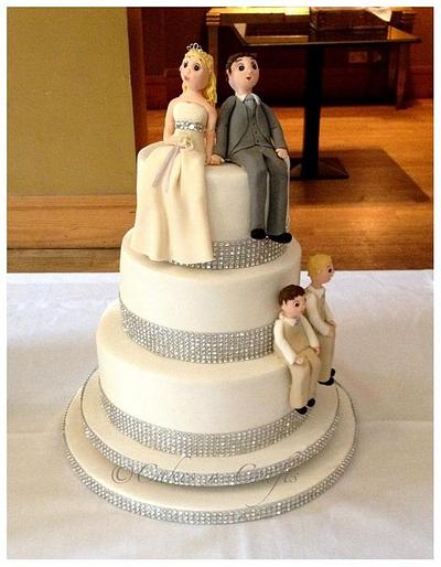3 tier wedding cake with diamante trim and edible bride, groom and their 2 boys - Cake by June milne