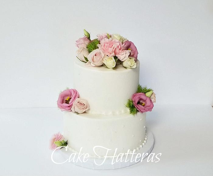 Buttercream iced wedding cake with fresh flowers