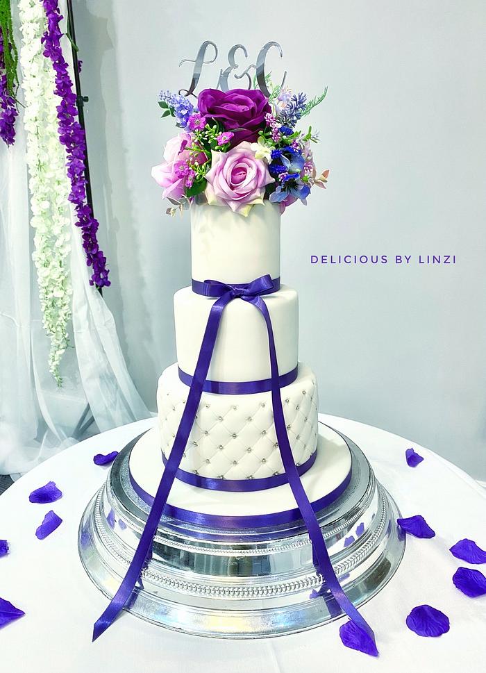 Purple and white 3 tiered wedding cake 