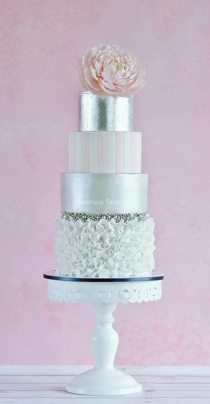 A double barrel cake with silver leaf and a peony