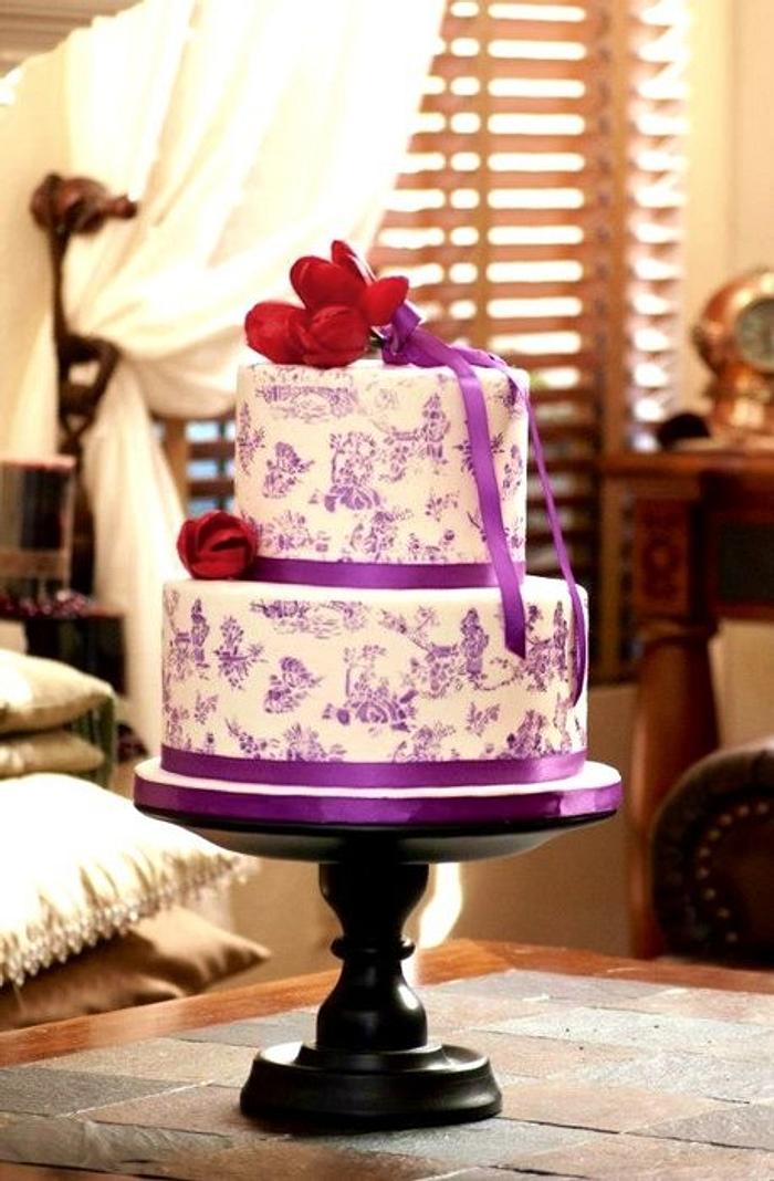 Purple toile stenciled cake with red tulips topper
