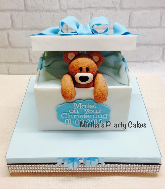 Teddy bear peeping out of a box cake