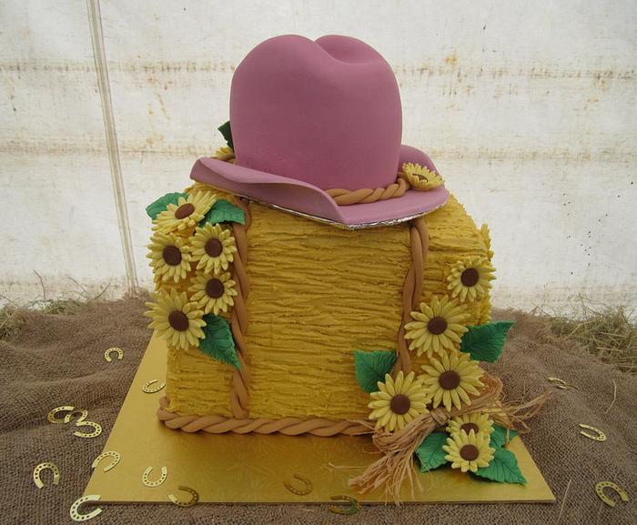 Hay bale, cowgirl hat and sunflowers
