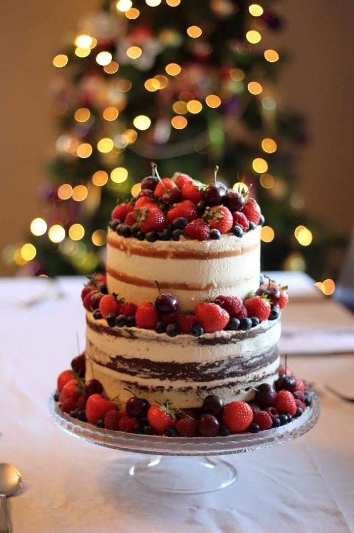 Naked chocolate and vanilla cake with fresh berries