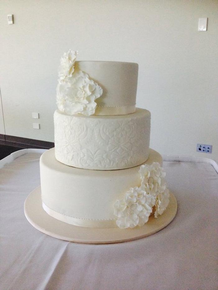 Ivory  wedding cake featuring white baroke stenciled centre 