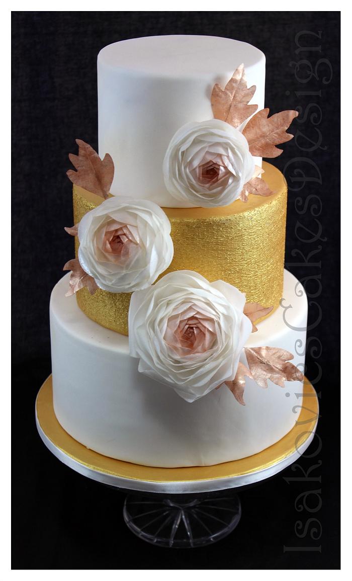 golden wedding display cake with ranunculuses