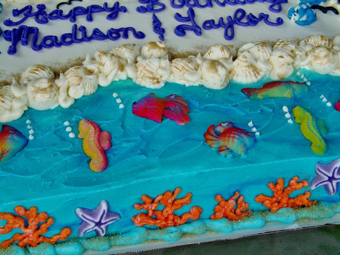 Beach cake in buttercream, sugar fish, and sanding sugar.