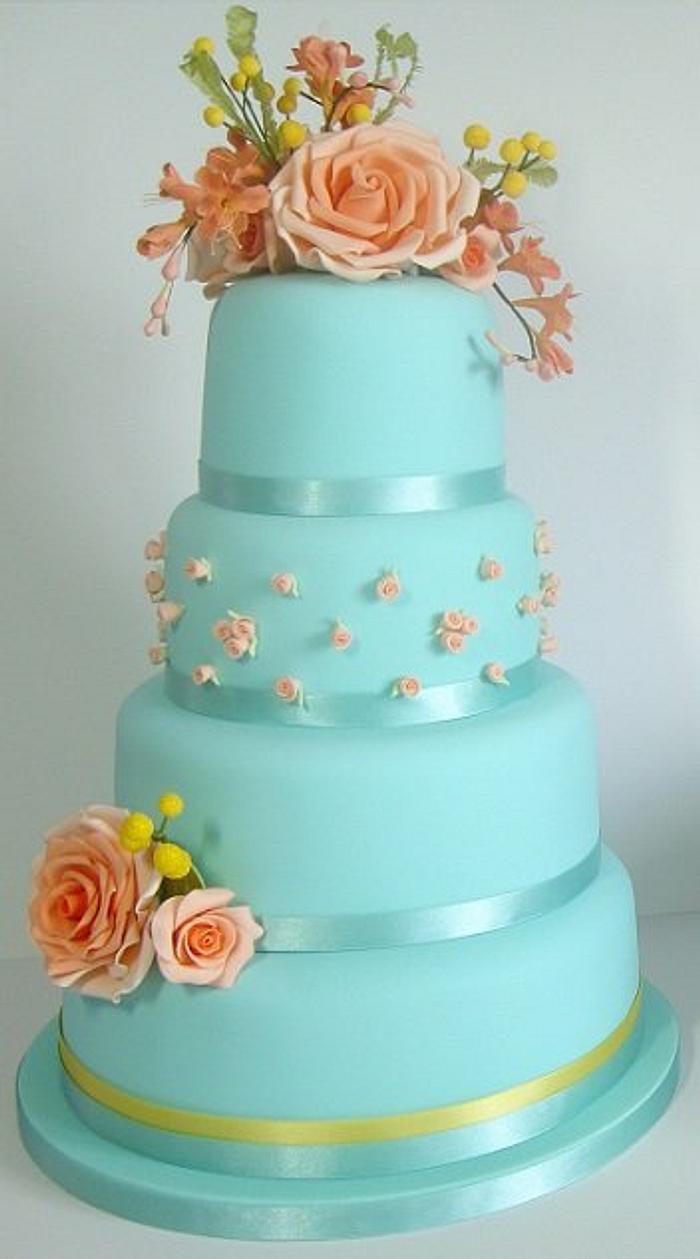 Blue cake with orange roses and freesias, and mimosas