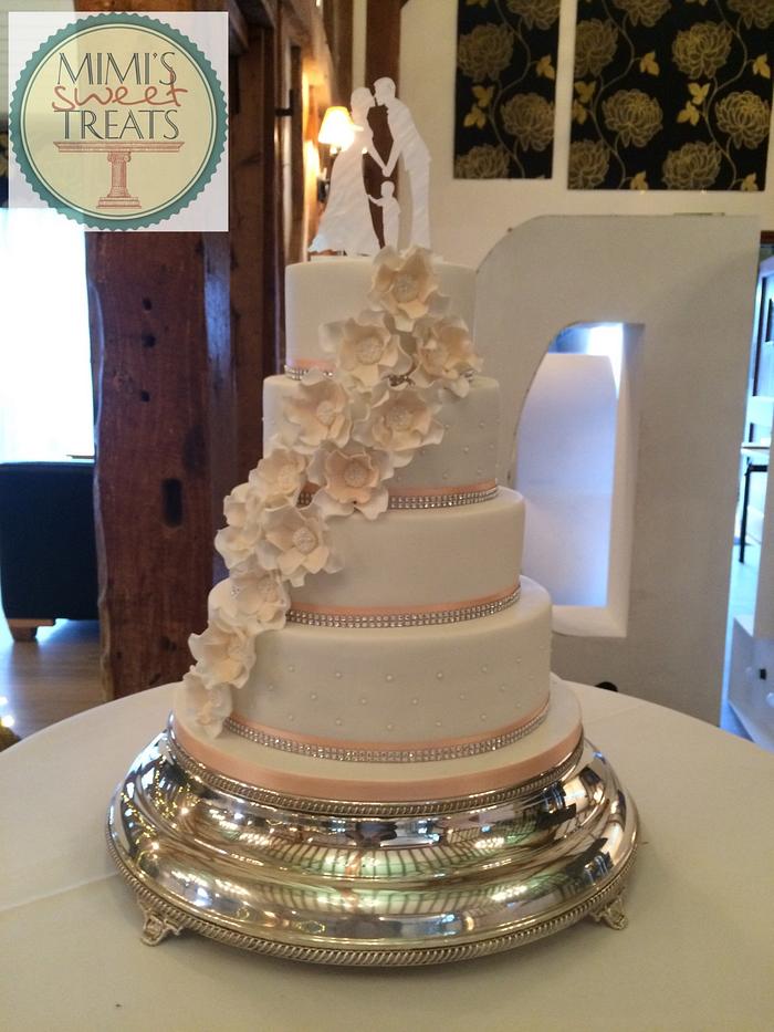 4 tier white wedding cake with peach accents