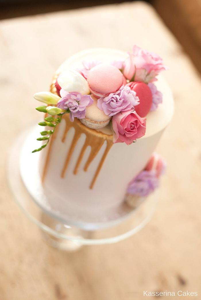 Delicate pink watercolour ombré birthday cake with gold drip, fresh flowers and macarons