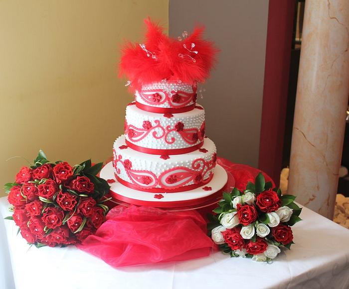 Three tiered Red and White Paisley print wedding cake with a red feather topper
