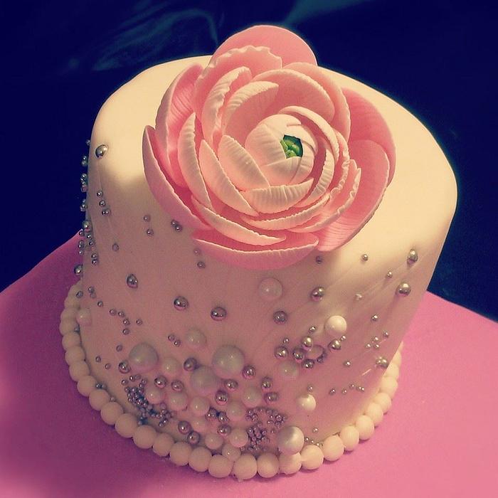 Small 6 inch cake with a sugar ranunculus flower