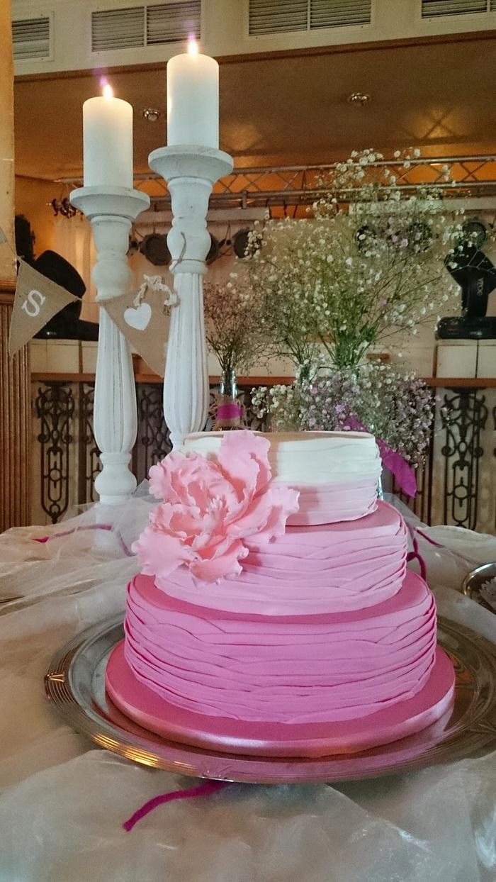 Pink ombre ruffled weddingcake with open peony