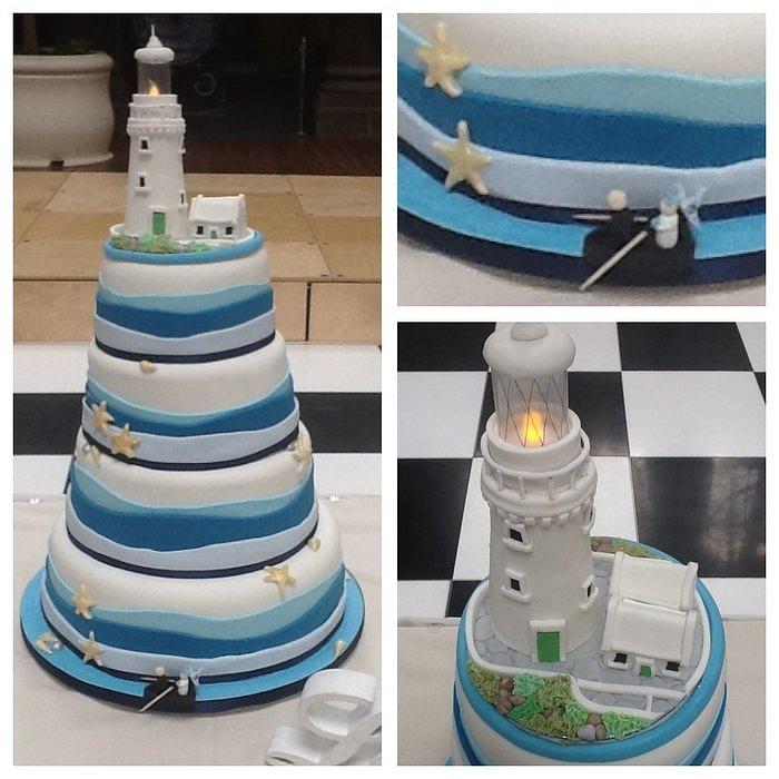 Nautical themed wedding cake with lighthouse topper