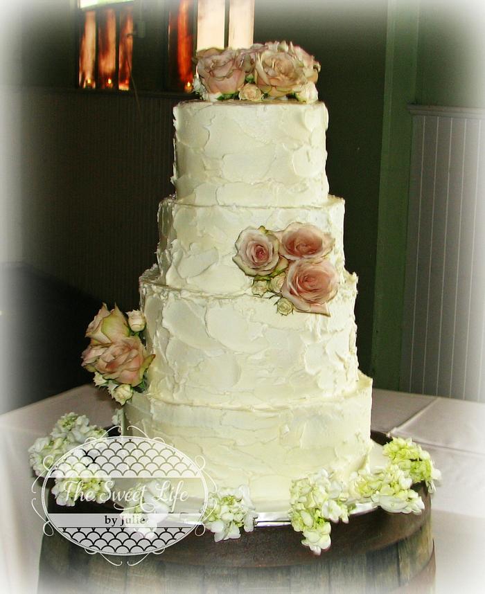 Rustic buttercream wedding cake with fresh roses