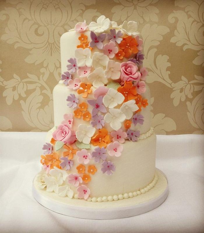 White wedding cake with sugar flower cascade