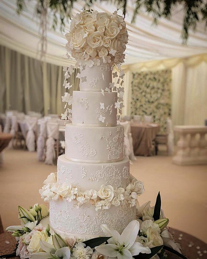 White and gold lace cake with floating hydrangea blossoms 