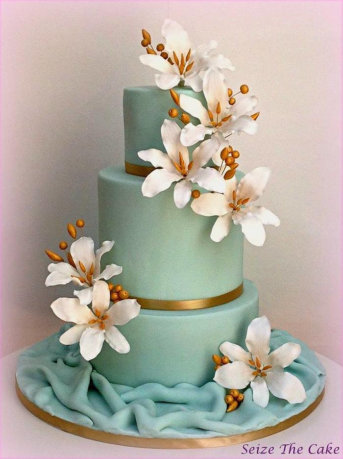 Wedding cake with sugar lilies and gold details