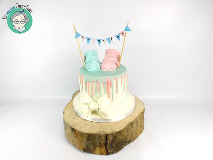 Gender reveal drizzle cake with edible crochet baby booties