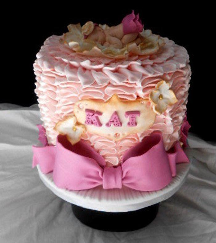 pink buttercream ruffle baby in a flower cake