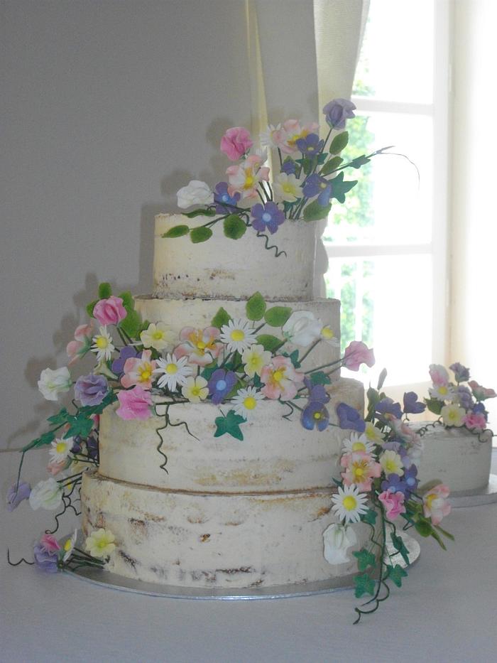 "Naked" wedding cake with wild flowers.