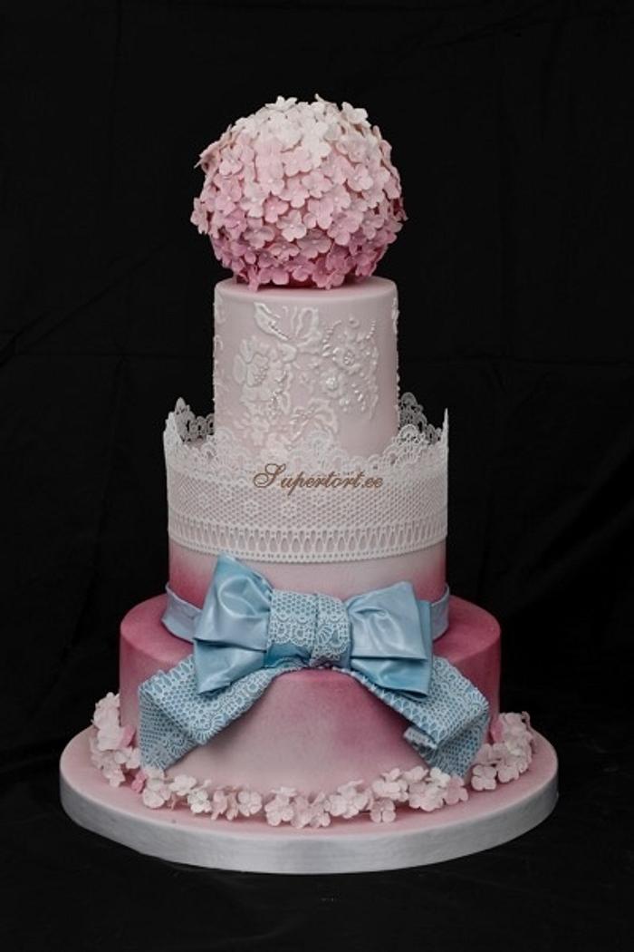 Wedding lace cake in pink with blue bow and hortensias