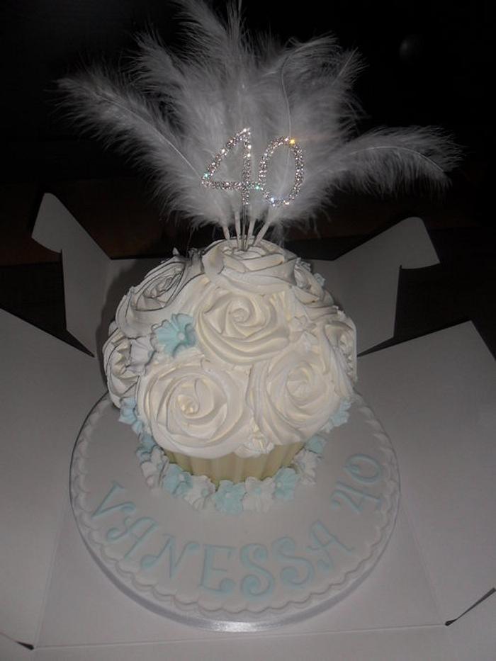 large giant white cupcake with feathers