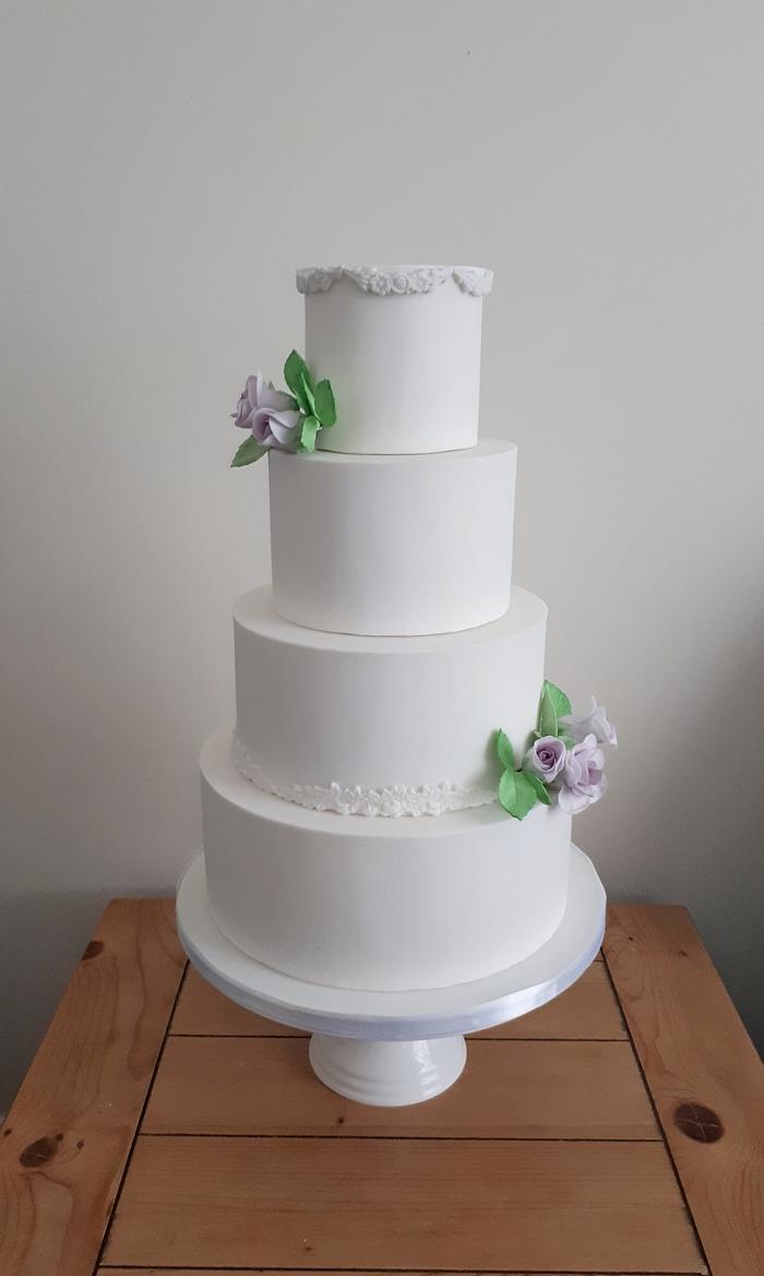 White wedding cake with lilac wired roses