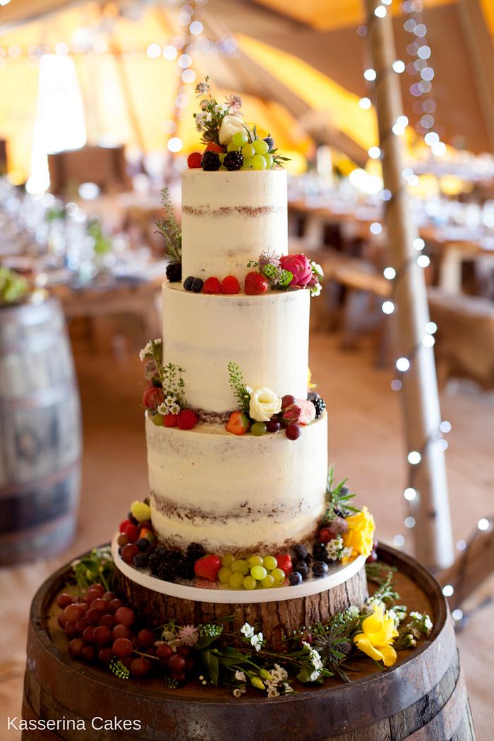Semi naked wedding cake with fresh fruit and flowers