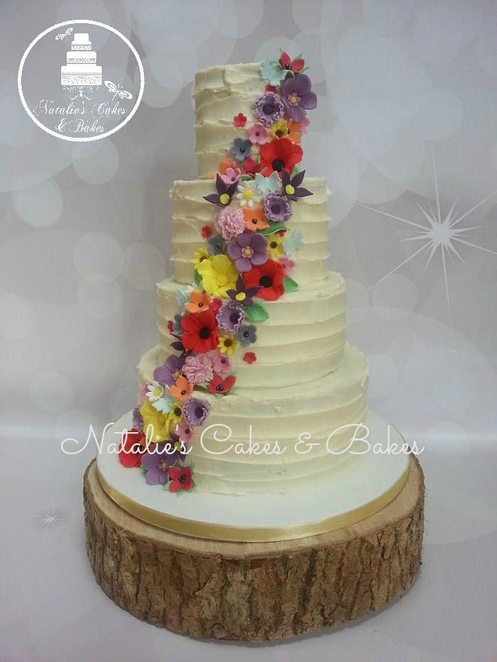 4 tier buttercream wedding cake with cascading flowers
