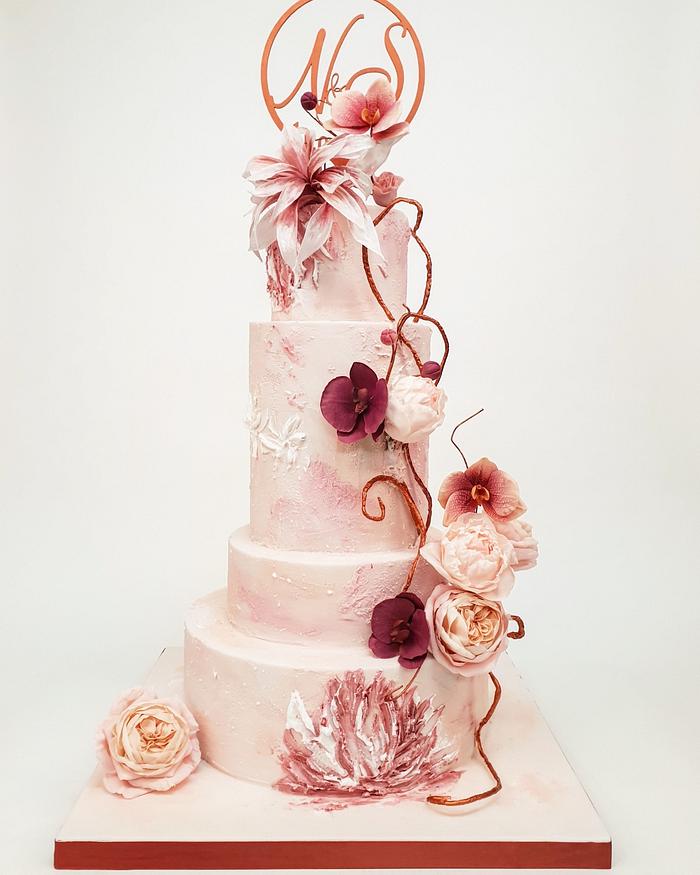 Pink and peach wedding cake with roses and orchids