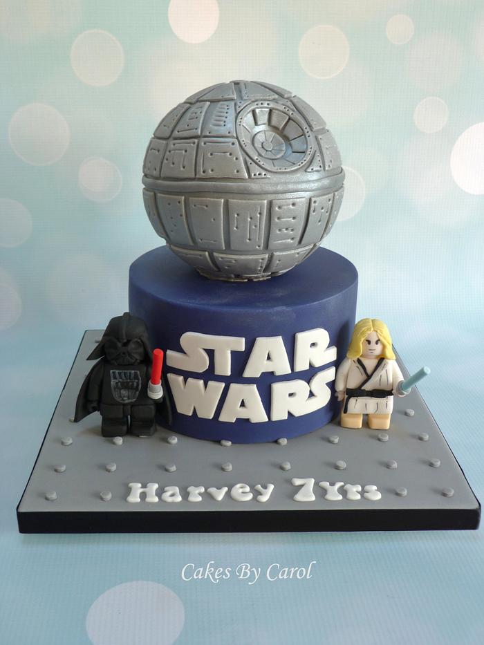 A Death Star cake with LEGO Minifigures from fondant at the base