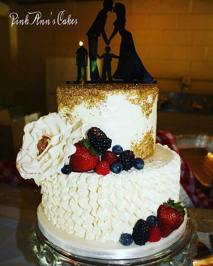 A gold berries and cream wedding cake