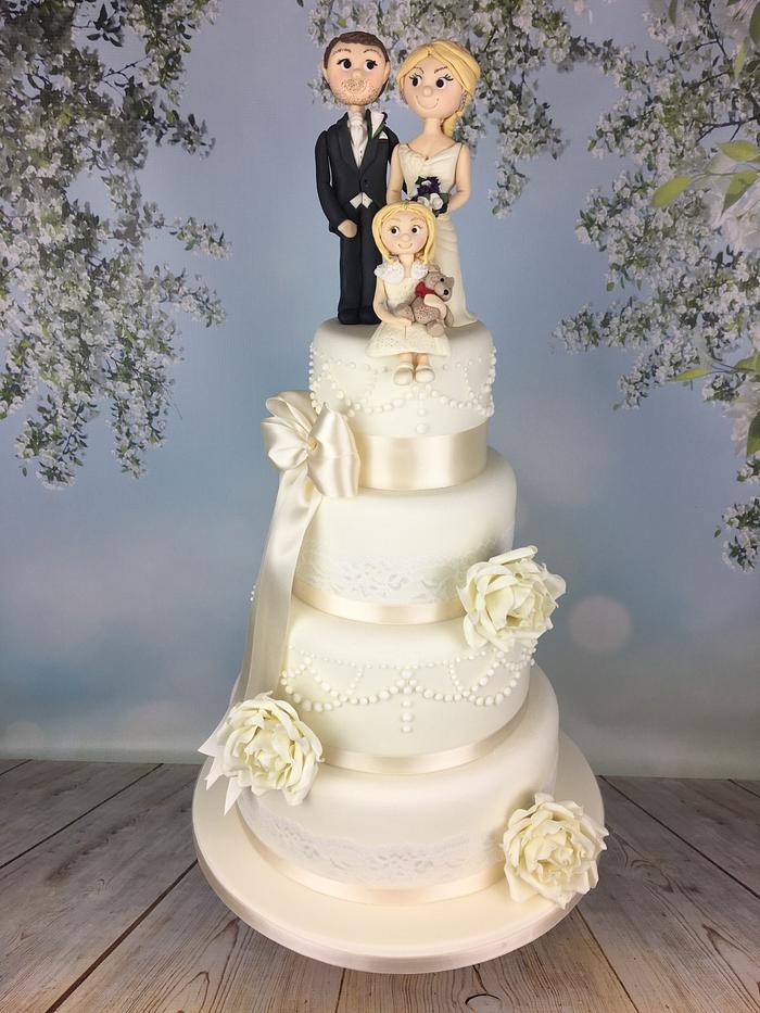Ivory wedding cake with bride groom and flower girl sugar topper 