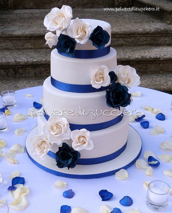 wedding cake with white roses and blue