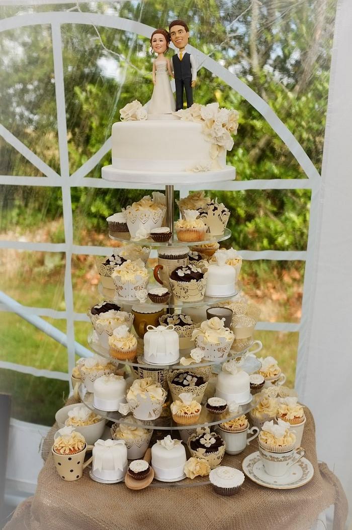 Vintage style cake and cupcakes at wedding.