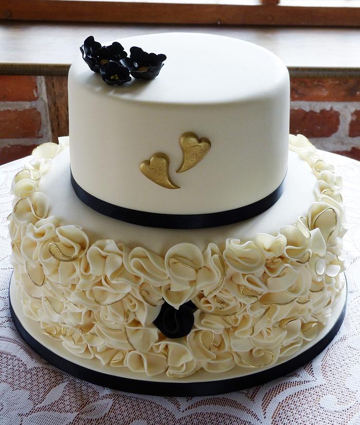 Ivory black and gold engagement ruffled cake