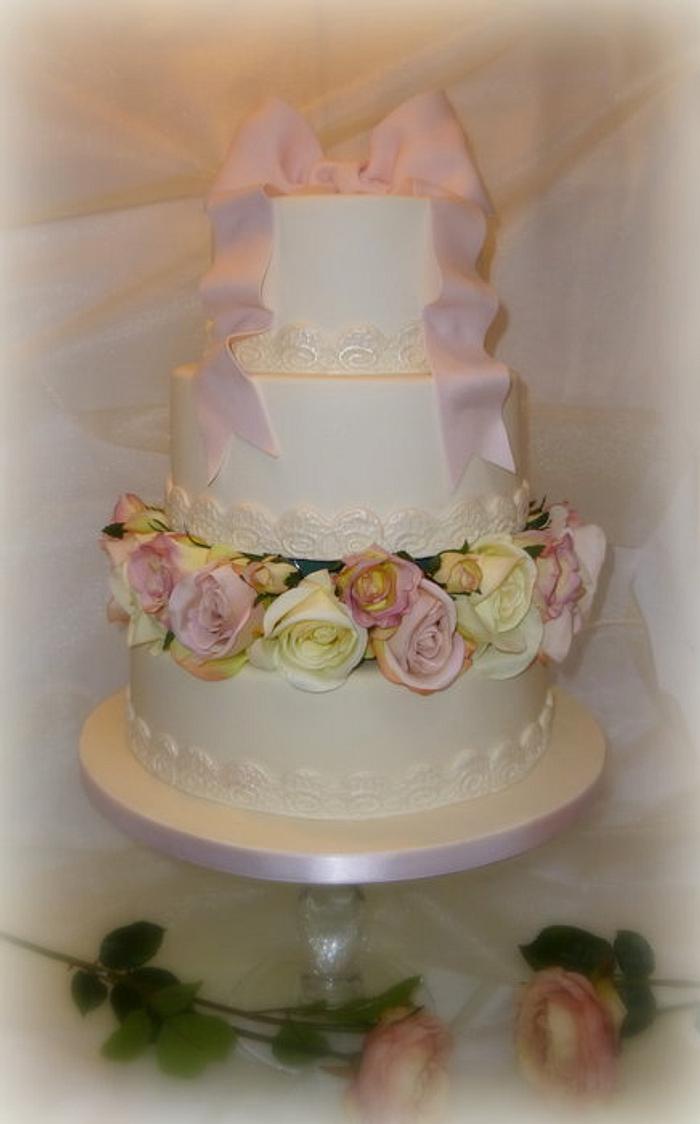 Ivory and pink bow and roses wedding cake