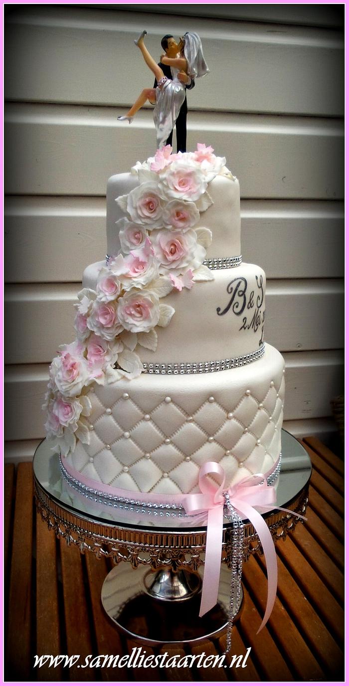 White weddingcake with a touch of pink