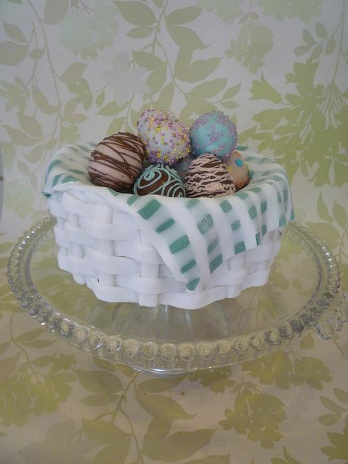 Traditional simnel cake basket with decorated cake pop eggs.