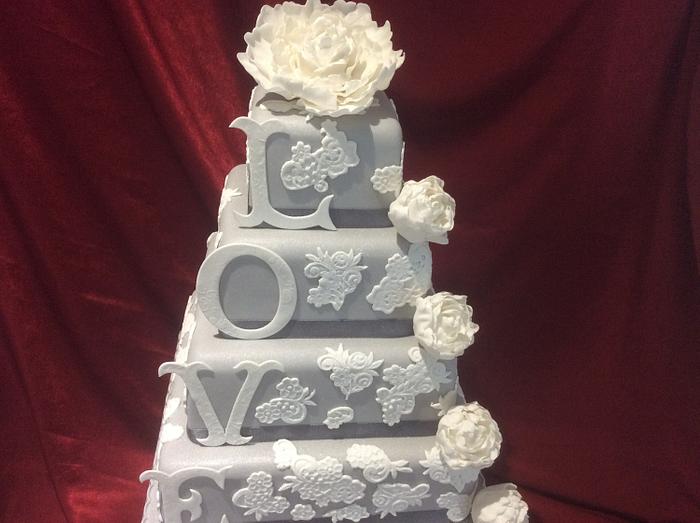 Grey and white lace wedding cake with peonies