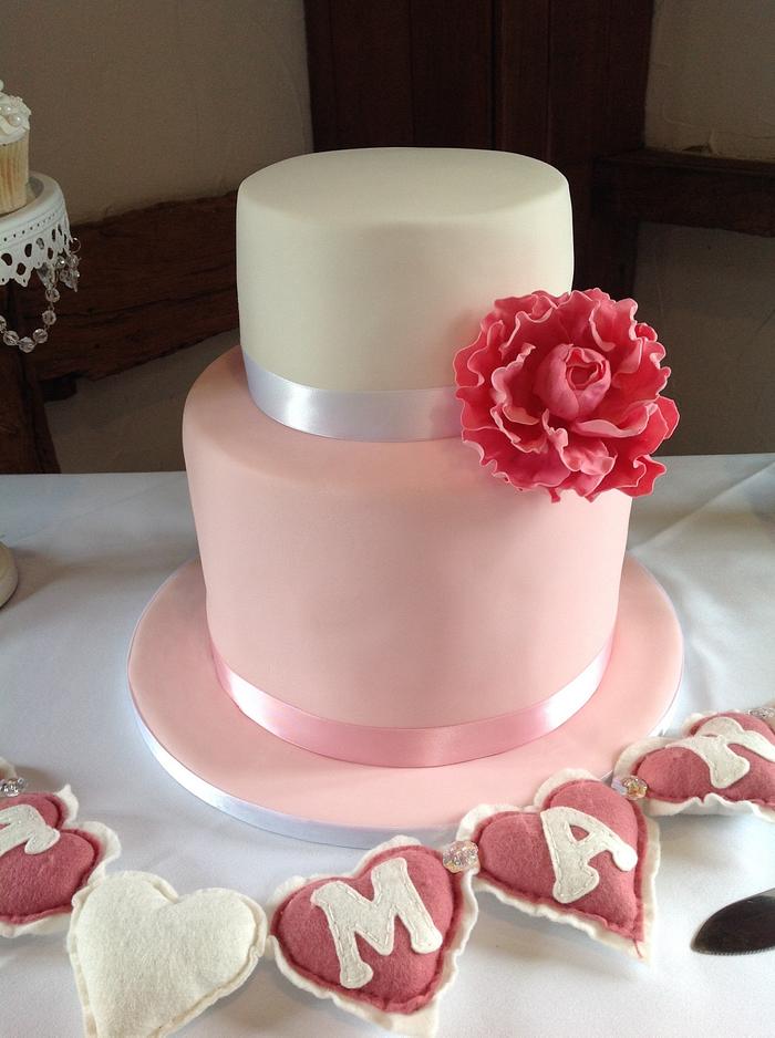 Pink and white wedding cake with peony