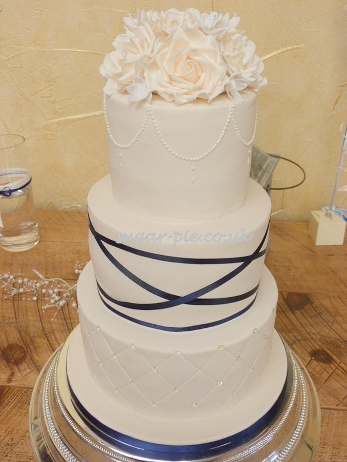 Navy ribbon and rose wedding cake