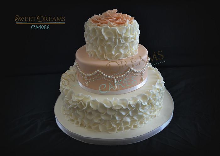 Wedding cake with ruffles and pearls.