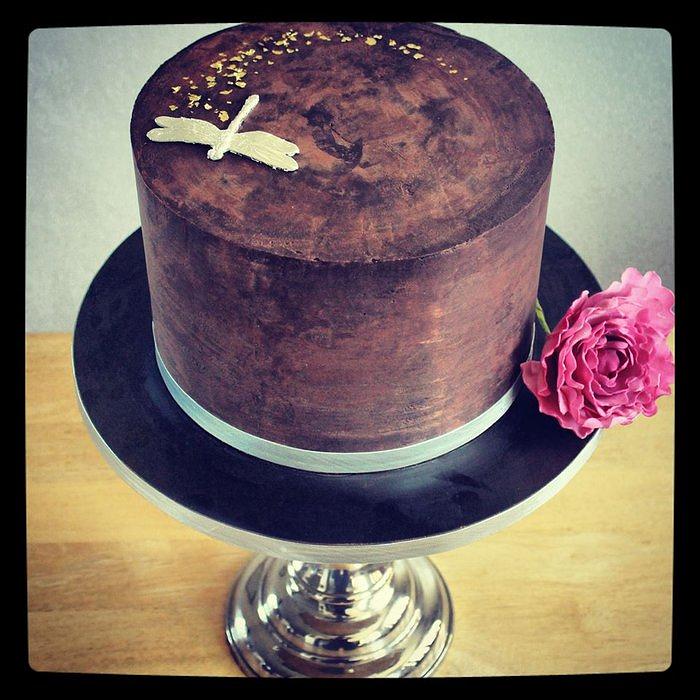 Minimalist ganache cake with silver-plated dragonfly and gold flakes