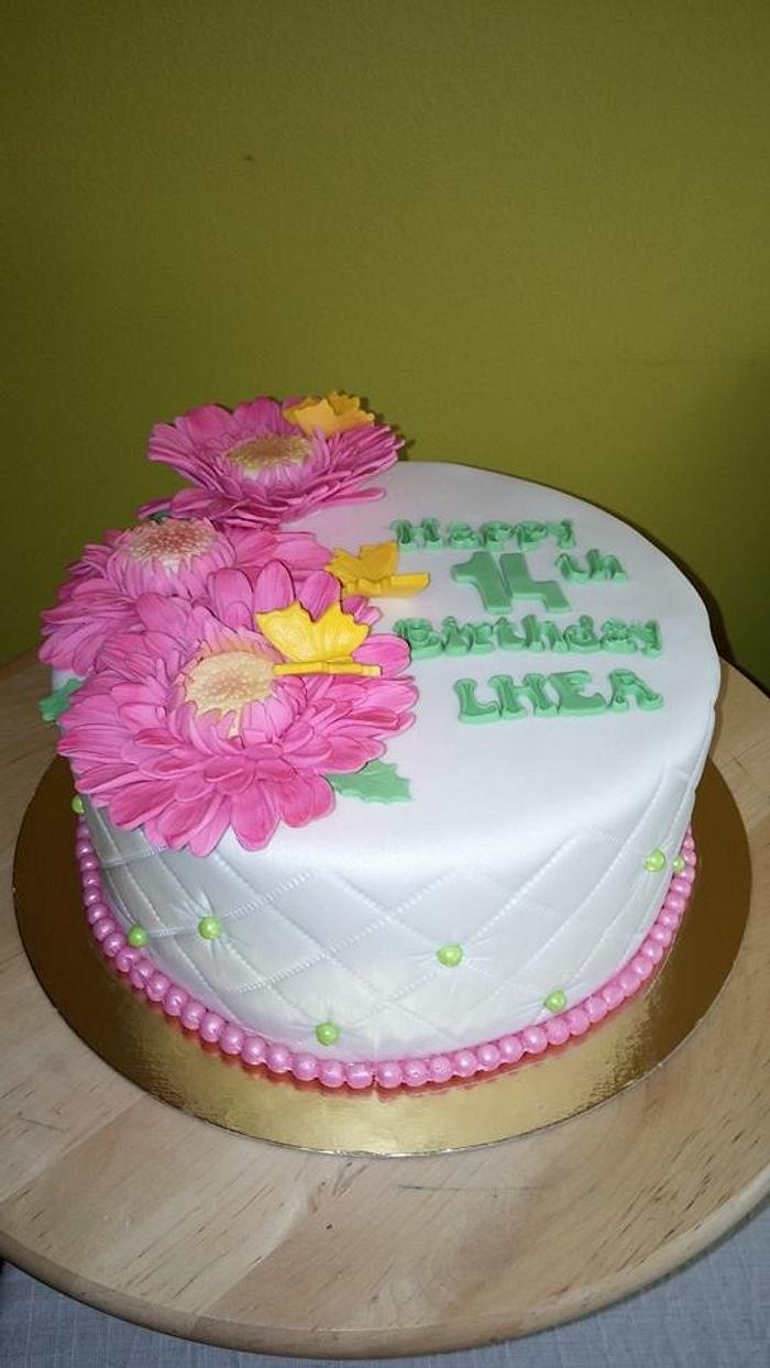 Pastel colored themed cake with gerber daisy