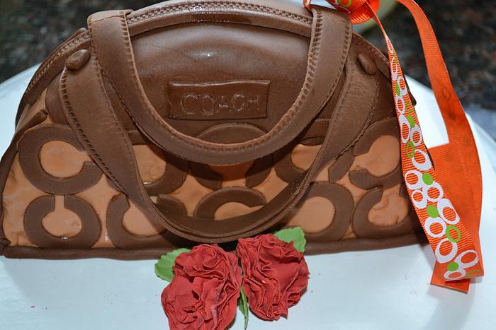 Brown coach bag and carnation.