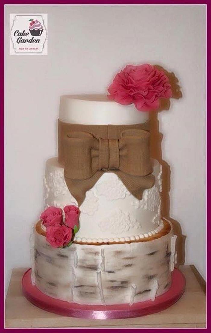 Rustic wedding cake with lace and bow